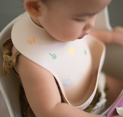 Baby wearing Ava and Oliver Silicone Bib Hawaiian Sea Animals