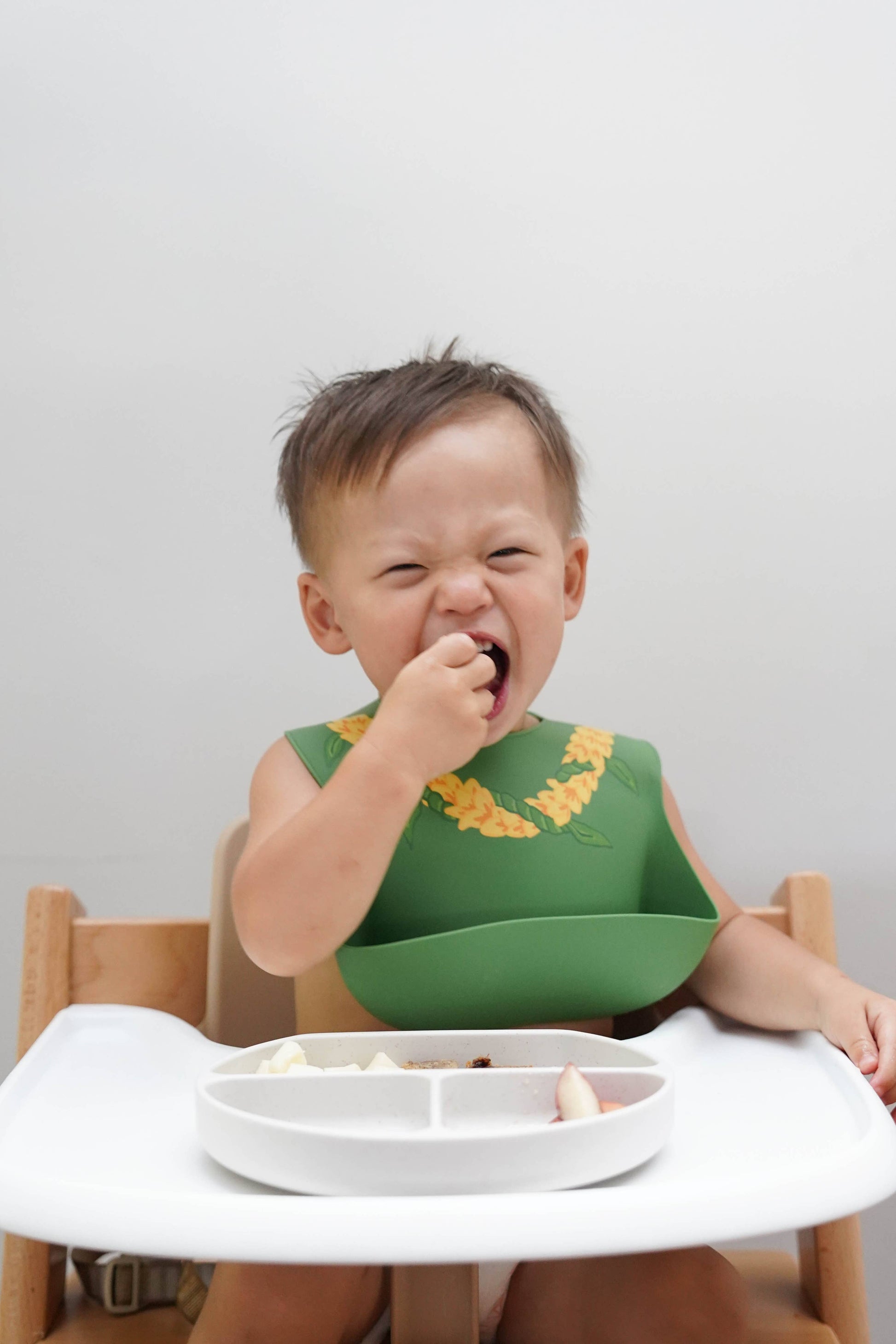 Baby eating in Ava and Oliver Silicone Bib Ilima Lei
